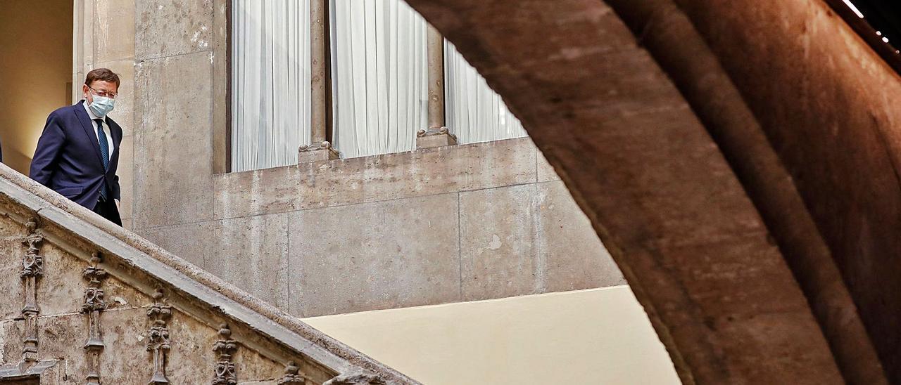 Ximo Puig baja por la escalera del patio gótico del Palau ayer antes de comenzar la rueda de prensa. | EFE/CÁRDENAS