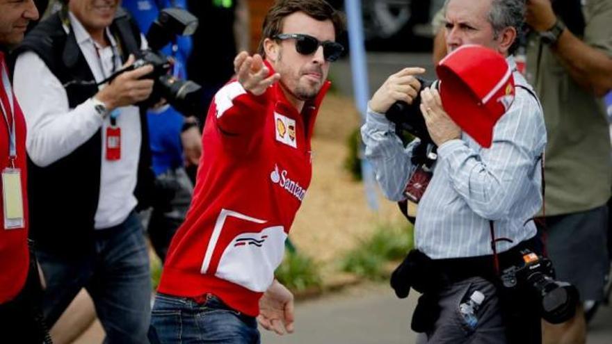 Fernando Alonso arroja su gorra a los aficionados en Albert Park. // Diego Azubel