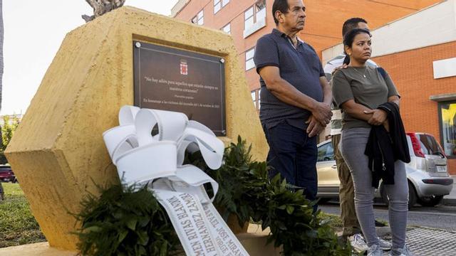 Familiares de las víctimas junto a la placa que las homenajea.