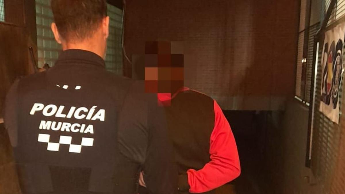 Un policía local de Murcia custodia al presunto maltratador detenido de madrugada en San Basilio.