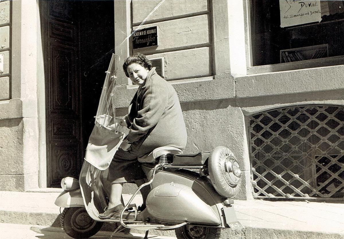 La poeta Gloria Fuertes, subida en una Vespa en la puerta de la casa madrileña donde nació, en el barrio de Lavapiés..