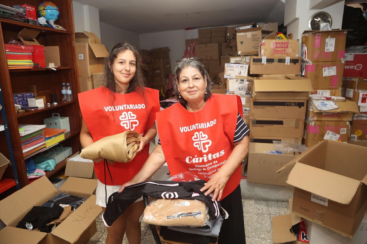 Laura y Marta Lucía, nieta y abuela, preparan lotes de equipamiento deportivo, en el local de Cáritas de la calle Pan de Soraluce, en Os Mallos.
