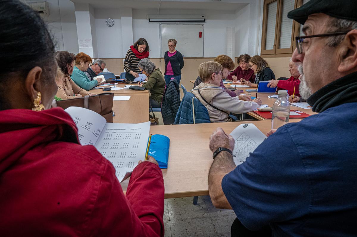 Clases en la escuela popular para adultos de la asociación Martinet Solidari, que imparte educación continua a adultos ante la falta de una escuela oficial