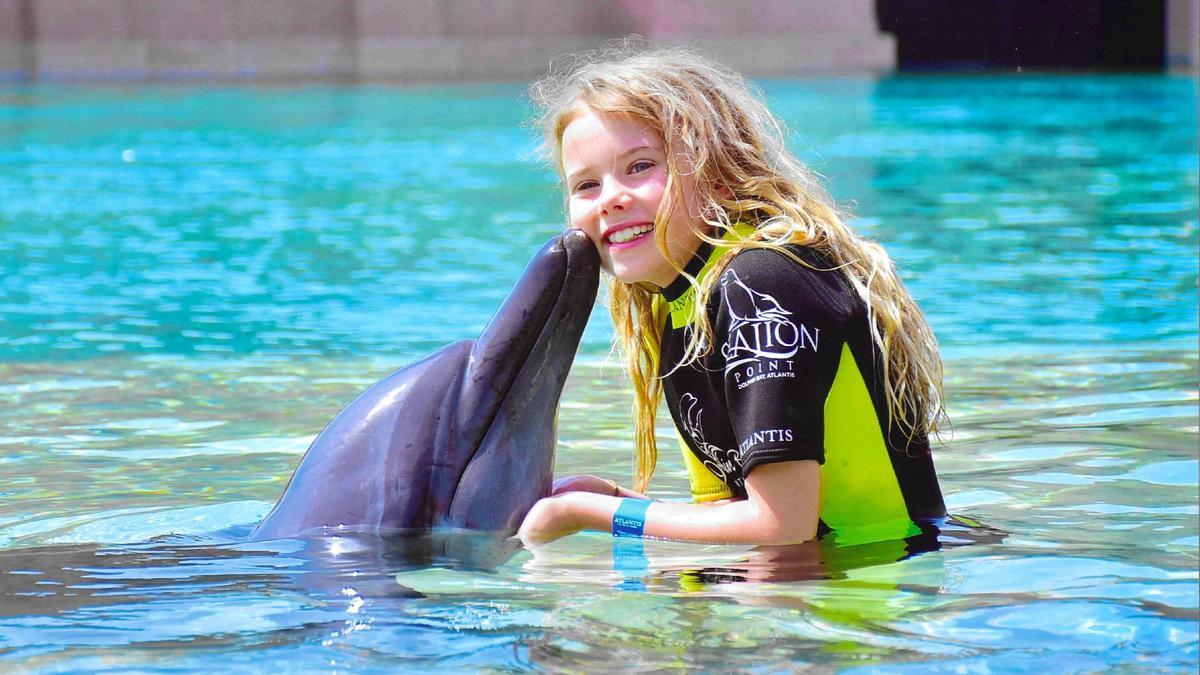 La pequeña Sofia jugando con un delfín.