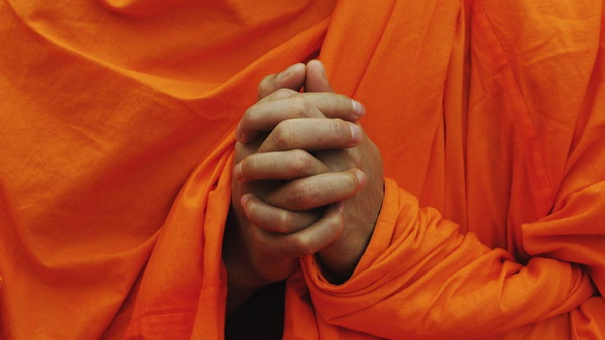 Un monje budista participa en un rezo colectivo.