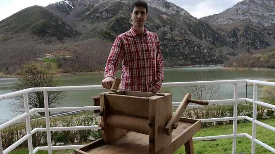 Francisco Cueria, con una máquina utilizada para la elaboración del queso casín, ante el pantano de Tanes.