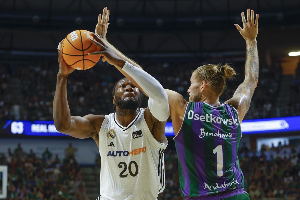 Málaga, 06/20/2025.- The Pivot of Real Madrid Bruno Fernando (i) plays a ball against Dylan Ostkowski, of Unicaja, during the fourth semifinal match of the Endesa Basketball League that Unicaja and Real Madrid play on Tuesday in the José María Martín Carpena pavilion, in Malaga. EFE/Jorge Zapata