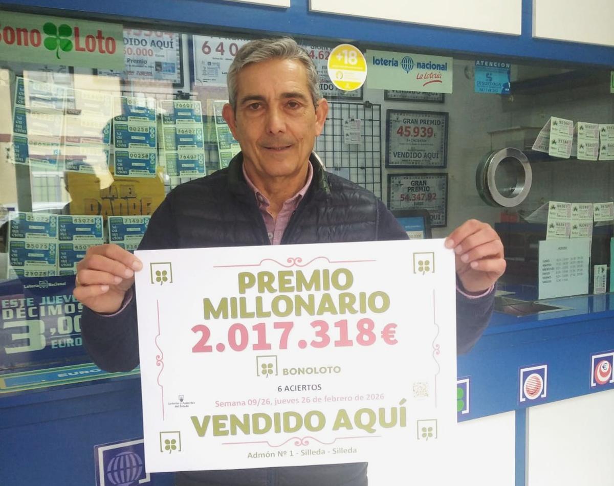 Gustavo Pousa con el cartel del premio de 2 millones repartido por su administración.