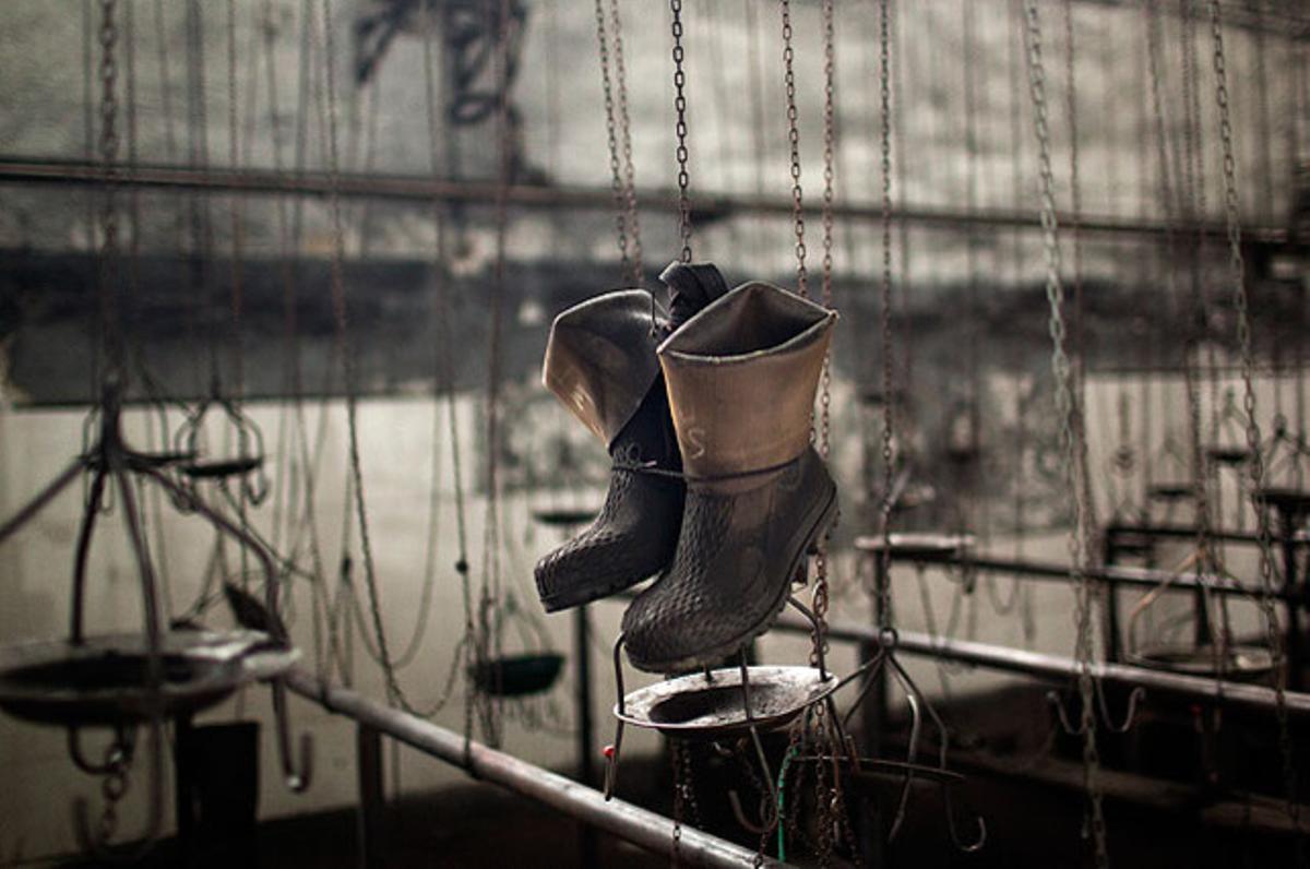 Un parell de botes pengen en un vestidor en una mina parcialment abandonada i tancada, mentre 8.000 miners continuen la protesta contra l’acció del Govern per reduir subvencions, a Mieres (Oviedo).