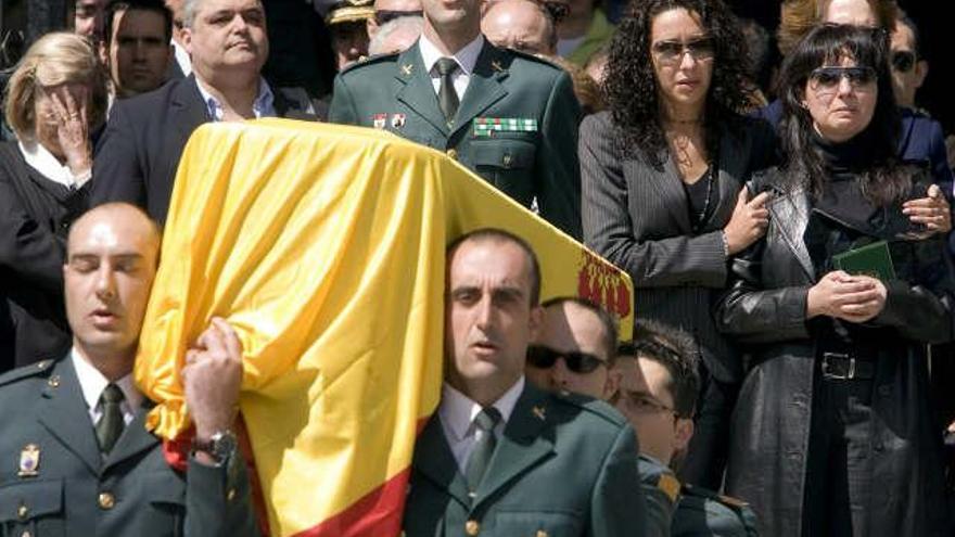 Momento de la salida de la Catedral Nueva de Vitoria del féretro con los restos mortales del guardia civil Juan Manuel Piñuel, asesinado en el atentado cometido ayer por ETA contra la casa-cuartel de la Guardia Civil de Legutiano (Álava), seguido de su viuda, María Victoria (d), y otros familiares.