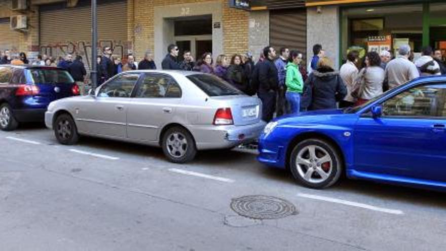 Decenas de premiados hacen cola para cobrar las papeletas de lotería de Tele Taxi, ayer, con los números repartidos el jueves.