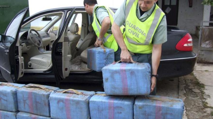 Agentes de la Guardia Civil descargan 24 fardos de hachís con un peso de 720 kilos que el ciudadano marroquí A.B., de 31 años, llevaba en un vehículo de gama alta al que se le había dado el alto en un control rutinario. El conductor del coche emprendió la fuga, pero fue localizado por un helicóptero que sobrevolaba la zona como apoyo al control de tráfico, cortandole el paso al huido a la altura del aeropuerto de Sevilla.