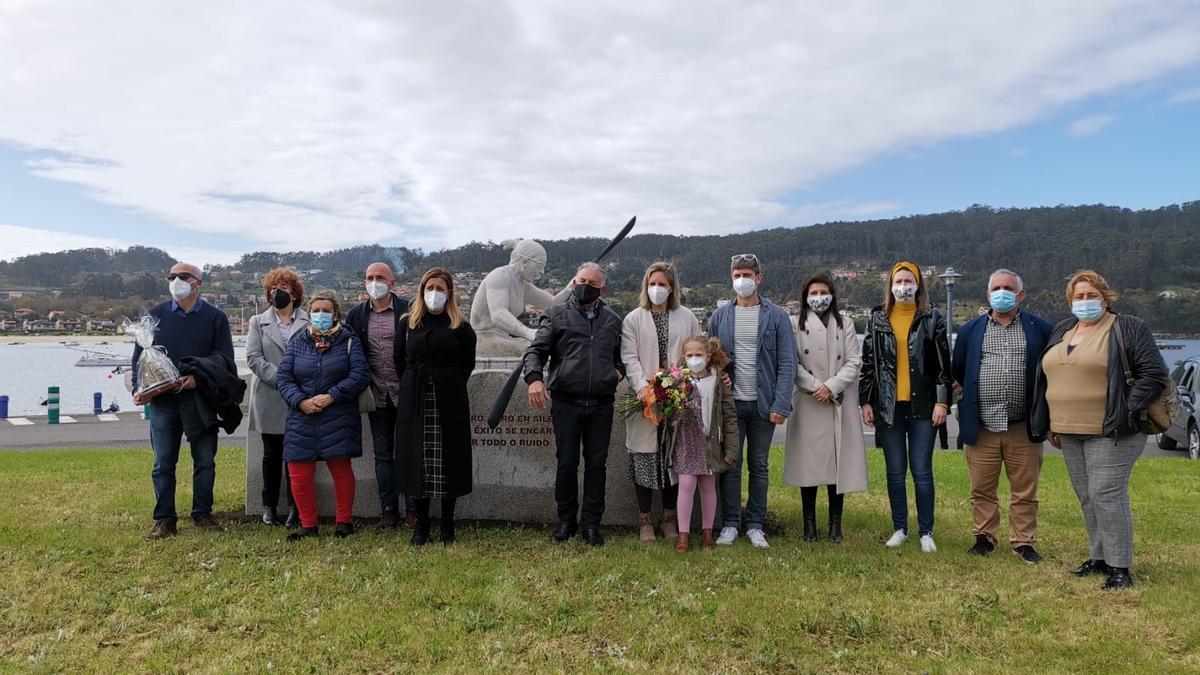 Teresa Portela, con un ramo de flores, ante la escultura en el acto de inauguración.