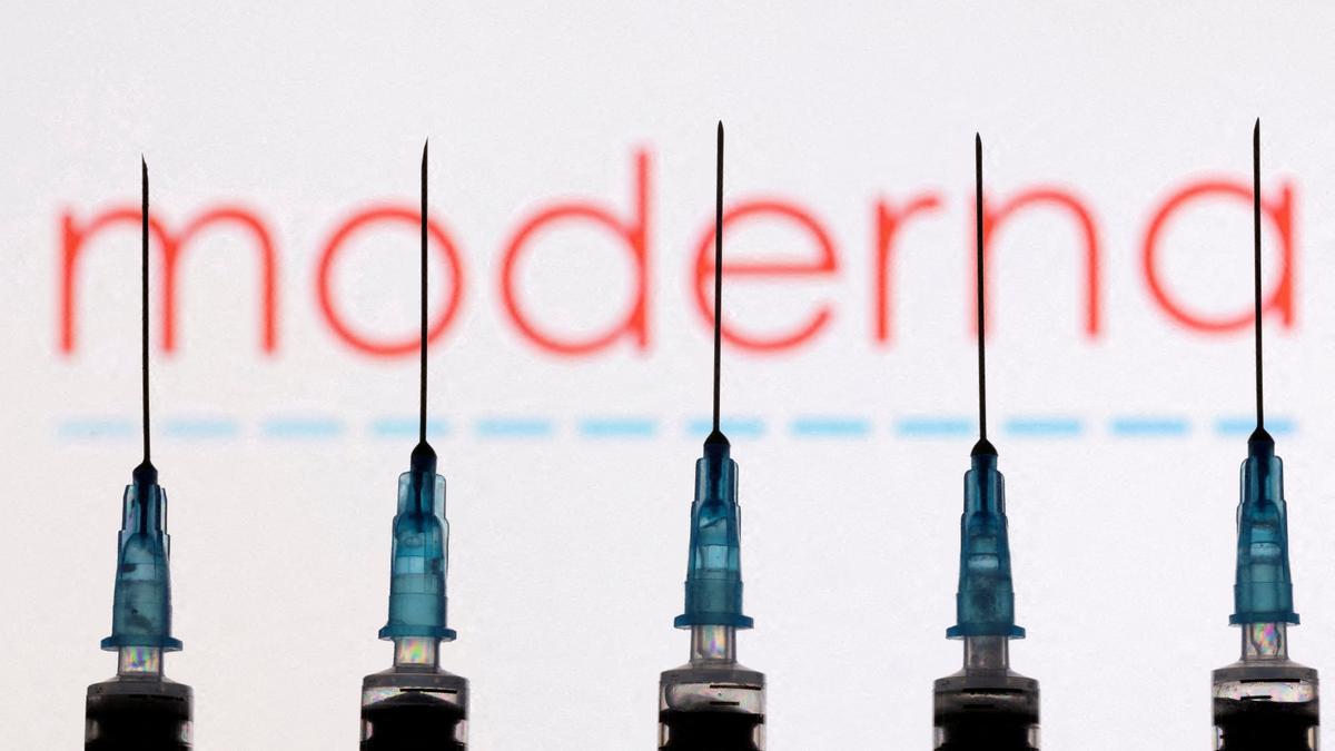 FILE PHOTO: Syringes with needles are seen in front of a displayed Moderna logo in this illustration