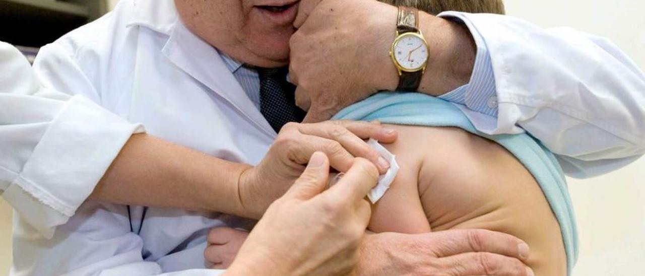 Un pediatra administra una vacuna a un niño.