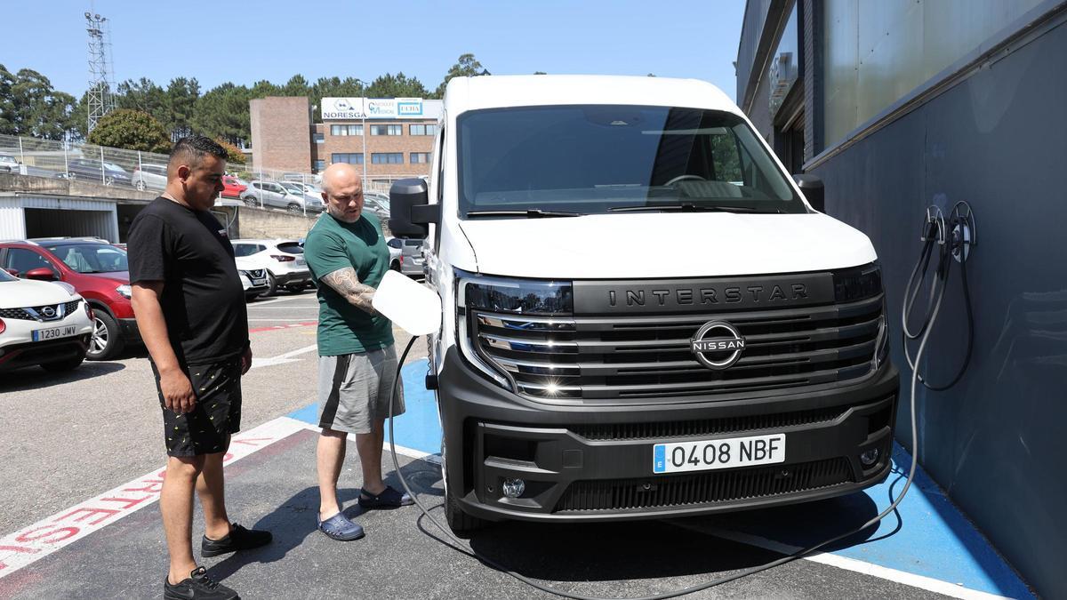 Dos personas cargan su furgoneta eléctrica en el concesionario de Rofervigo (Nissan).
