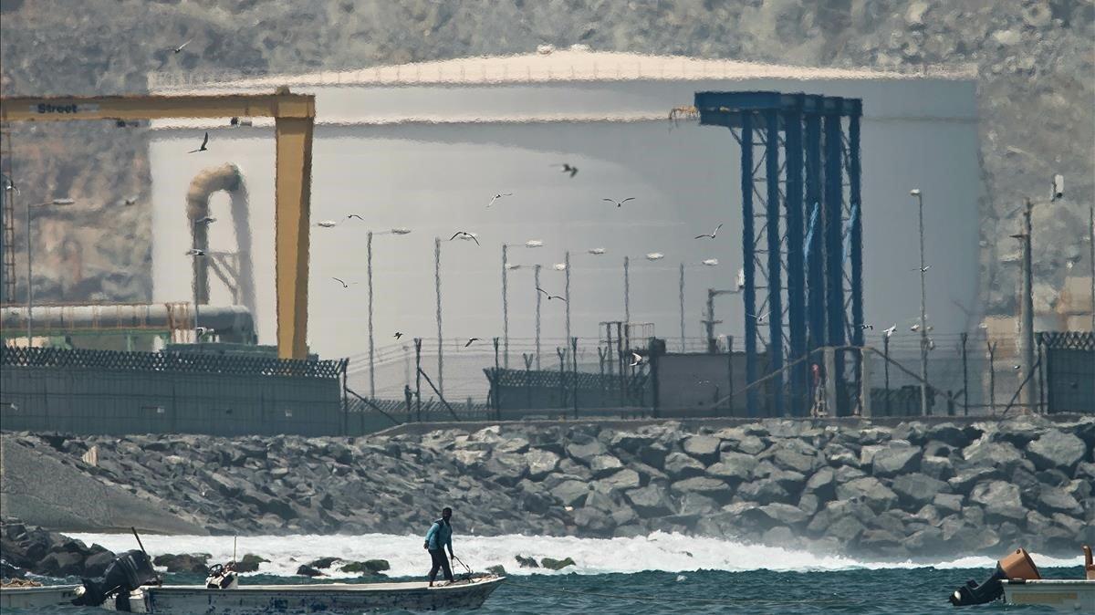 zentauroepp48134348 a fisherman prepares his boat near an oil storage tank in fu190514135009