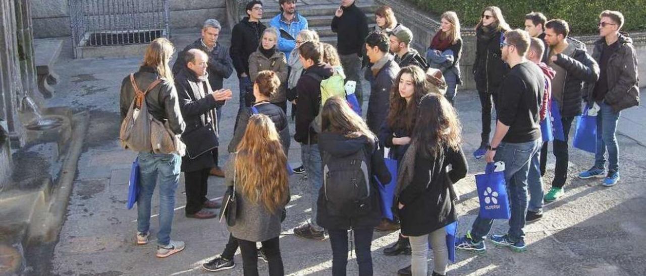 Uno de los grupos que ayer visitaron el casco histórico, en la fuente de As Burgas. // Iñaki Osorio