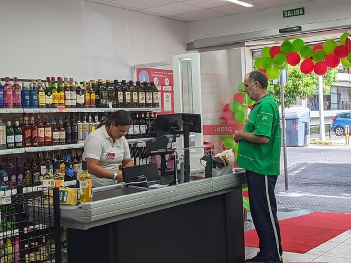 Una cajera y un cliente en la tienda Proxi del barrio de la Fuensanta.