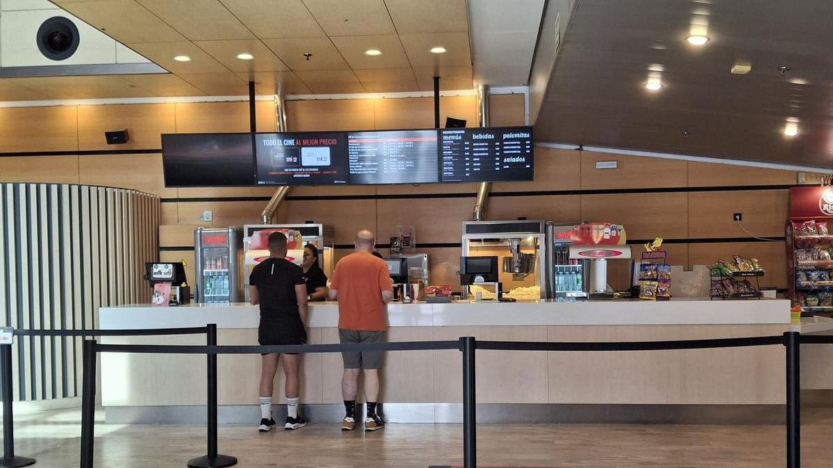 Dos clientes compran sus refrescos antes de acceder a una de las salas de los cines Conquistadores.