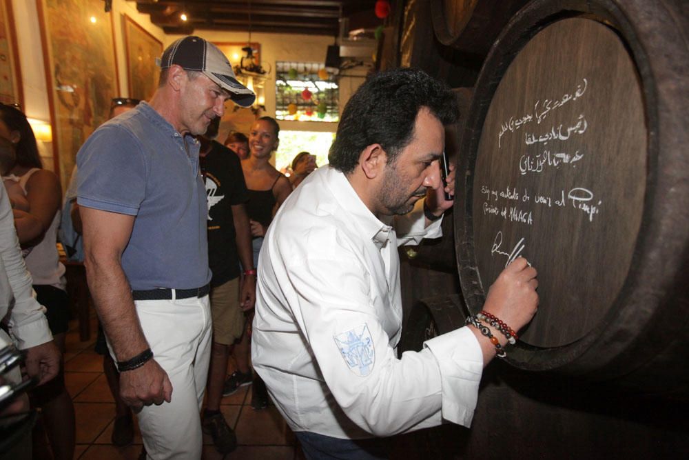 El actor y el jeque han recibido el Pin de Oro de El Pimpi de manos de su propietario, Pepe Cobos, con un diseño exclusivo que une la imagen de la bodega con el escudo del Málaga CF.