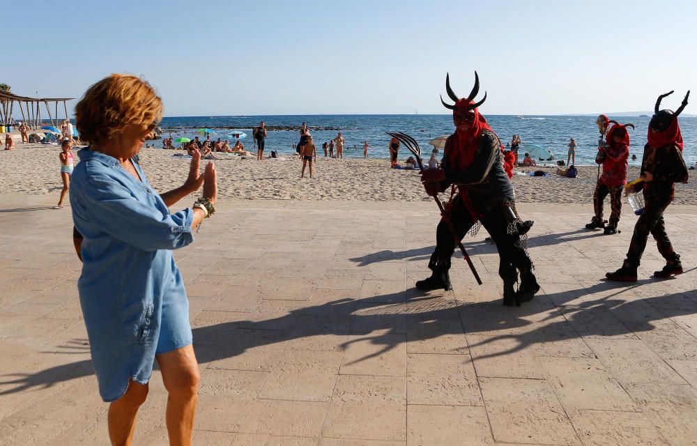 Los ‘dimonis’ del pasacalles del Molinar divirtieron a bañistas, paseantes y clientes