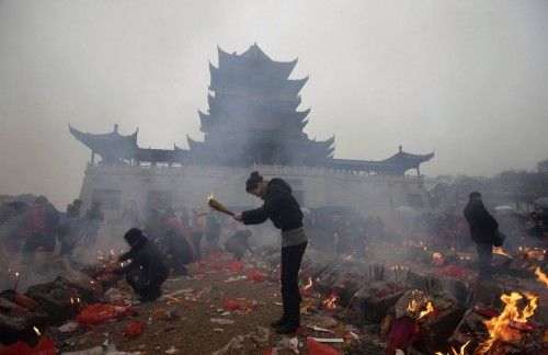 Devotos queman incienso para rezar por la prosperidad en el quinto día del Año Nuevo Lunar Chino