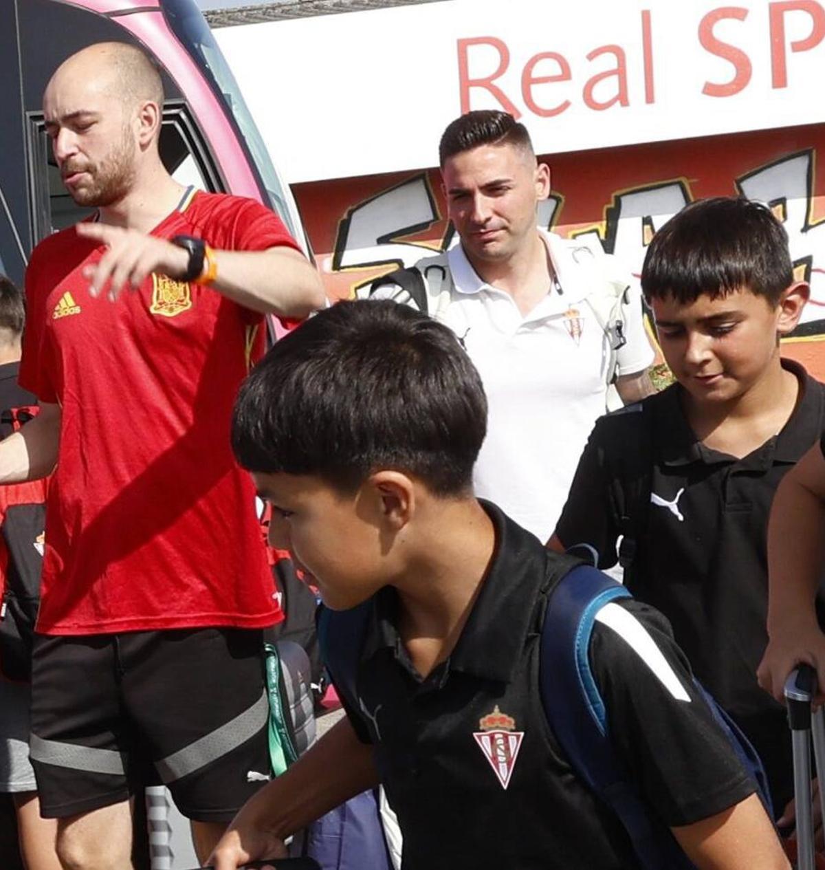 Al fondo, de blanco, Javi Reinaldo, junto a Pedro González Fuente, ayer, a la llegada del autocar, entre los alumnos del campus. | MIKI LÓPEZ