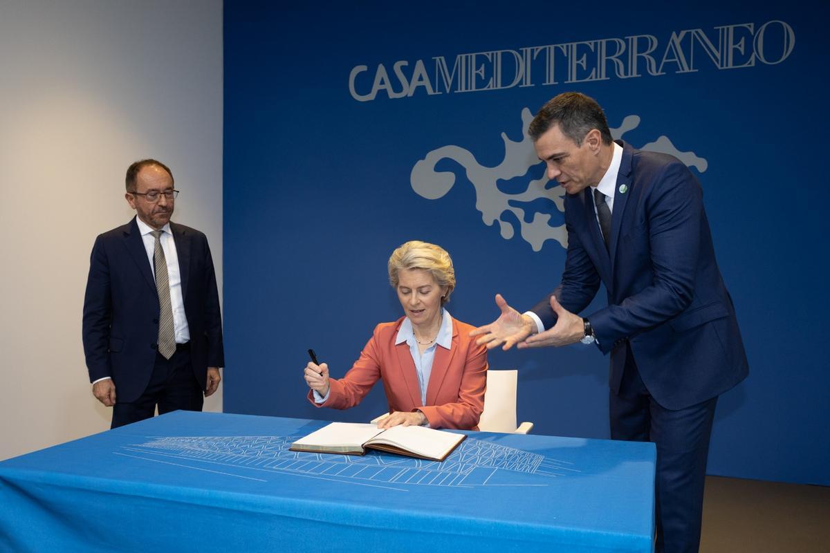 Ursula von der Leyen firmando en el libro de Casa Mediterráneo junto a Perelló y Sánchez.