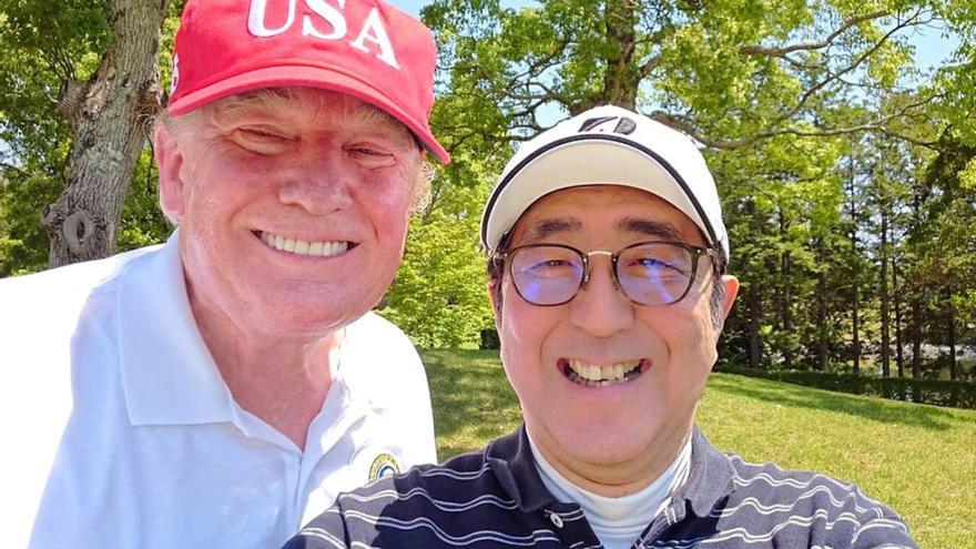 Trump posa en un campo de golf con Shinzo Abe.