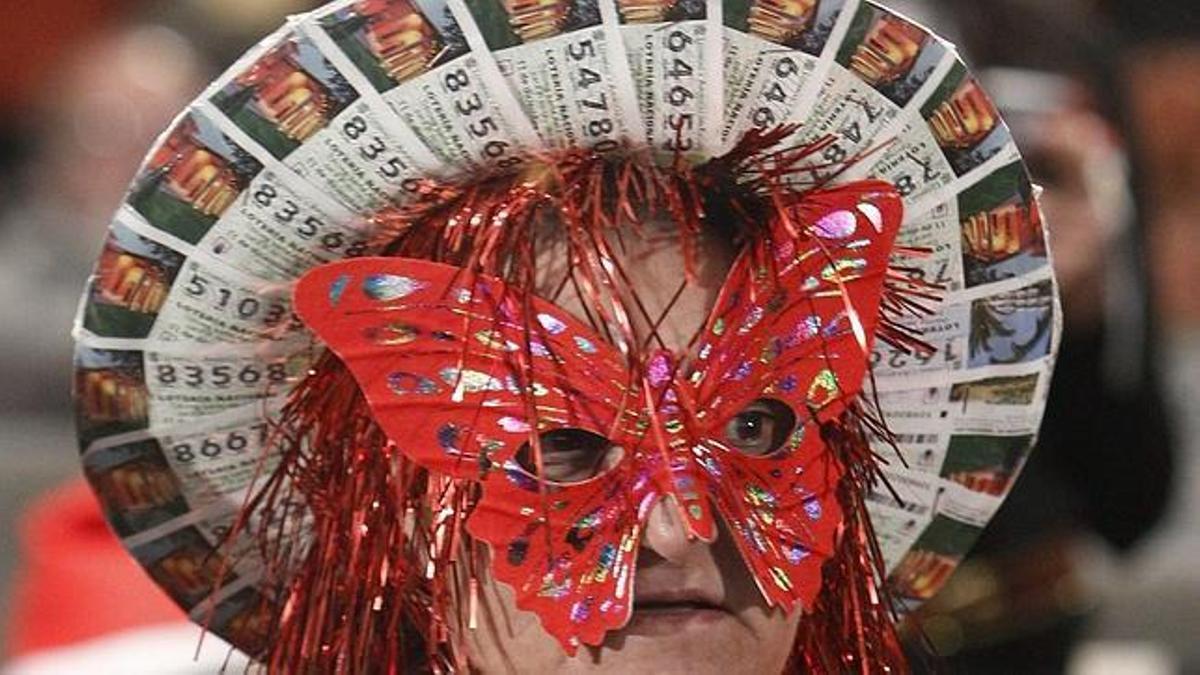 Una mujer disfrazada con un sombrero de décimos de la Lotería de Navidad de hace años.