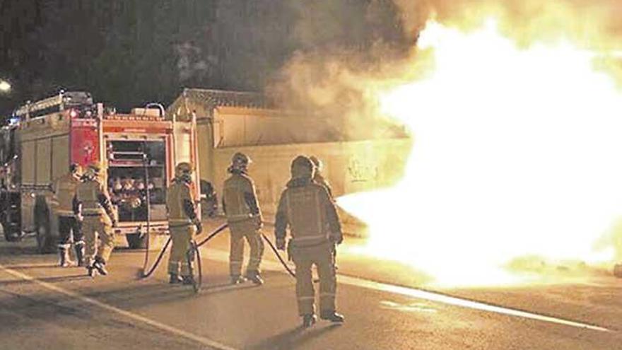 Varios bomberos, el domingo por la noche junto a varios contenedores en llamas en Son Cladera.