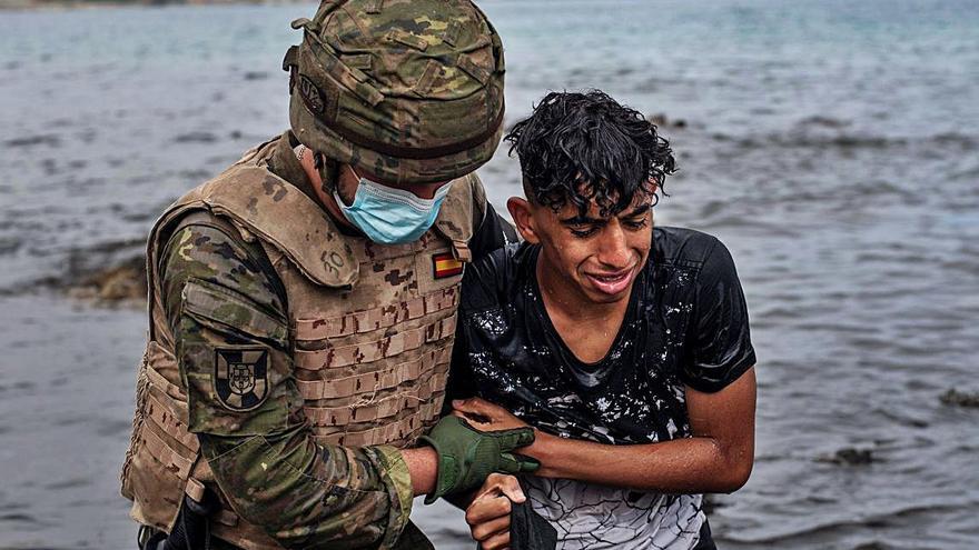 Un soldat ajudant un jove marroquí que va arribar nadant a Ceuta.  | BRAIS LORENZO