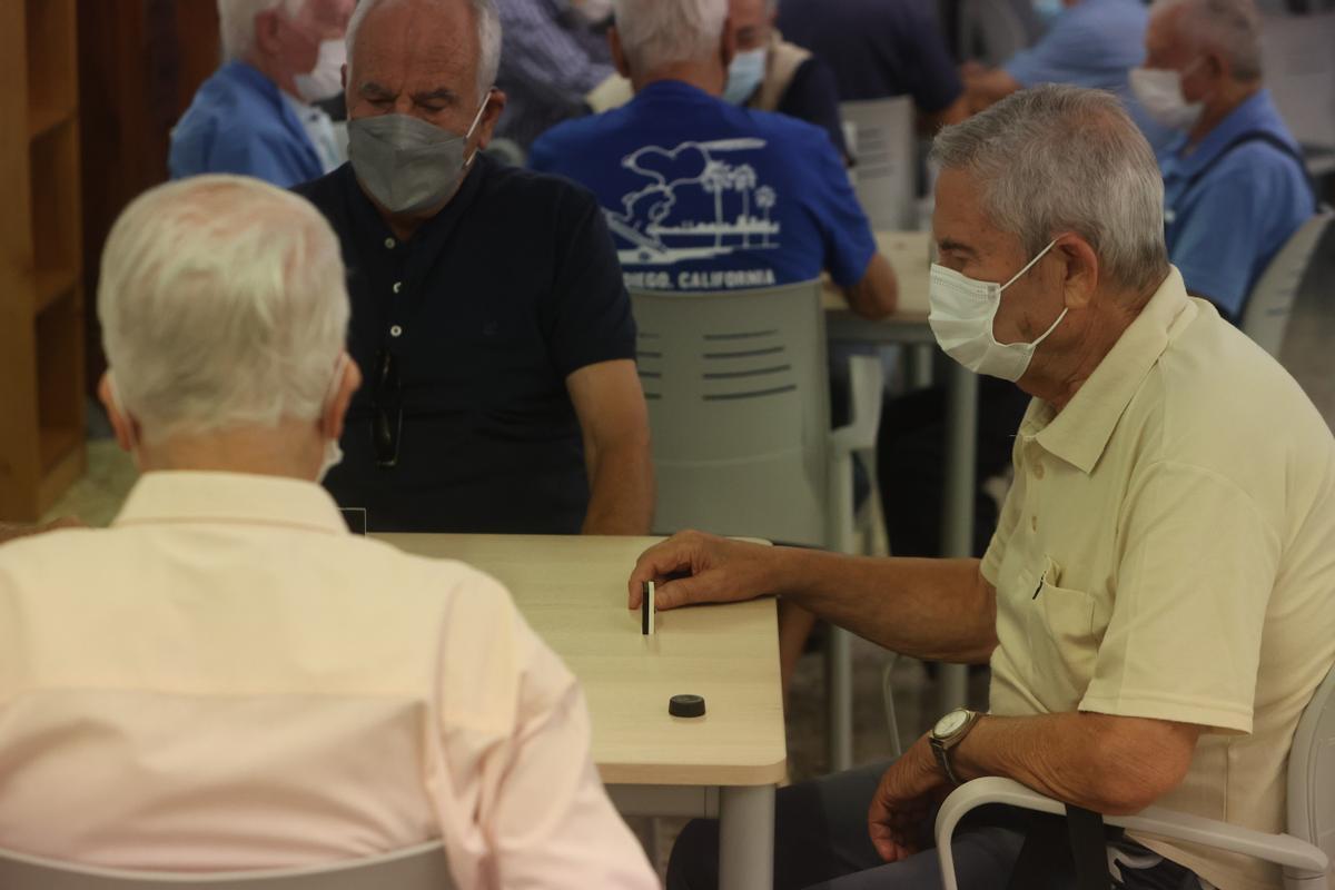 Varios pensionistas juegan al dominó en un centro social de Alicante.