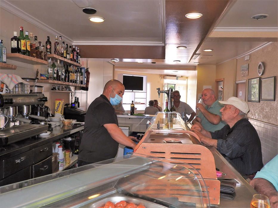Un grupo de clientes, vecinos de Sant Ferran, en el bar Verdera de la localidad.  C. C.