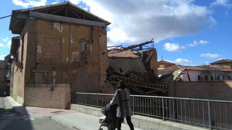 Una vecina observa los muros del palacio de Bustamante que se han desplomado recientemente.