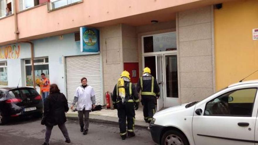 Los bomberos entrando en el portal de la vivienda afectada.  //