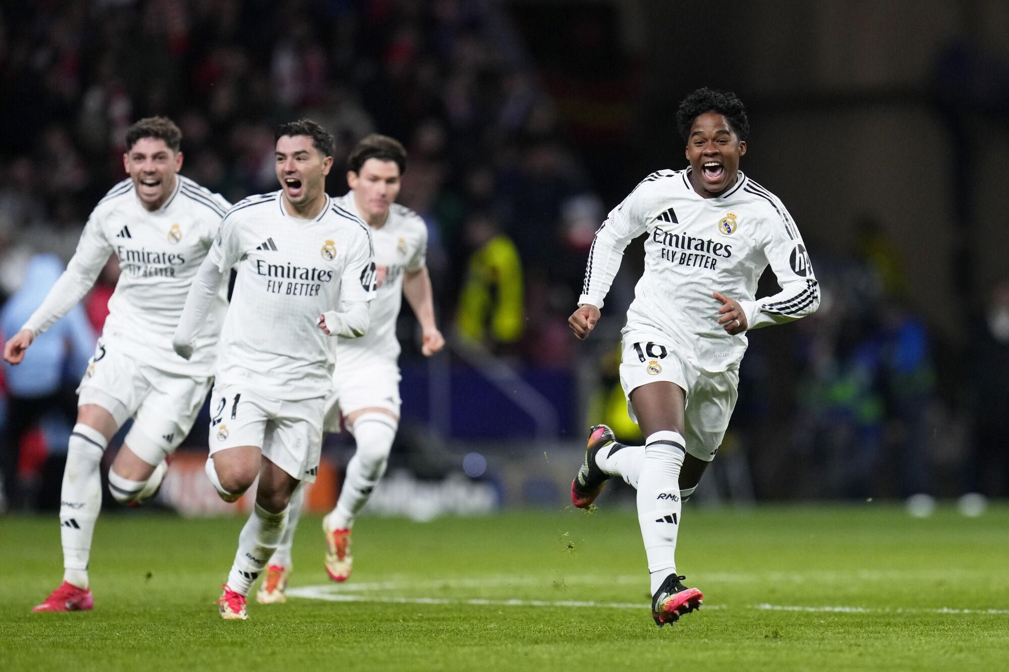 Real Madrid's Endrick, right, and his teammates run celebrating after a penalty shootout at the end of the Champions League round of 16, second leg, soccer match between Atletico Madrid and Real Madrid at the Metropolitano stadium in Madrid, Spain, Wednesday, March 12, 2025. (AP Photo/Manu Fernandez). EDITORIAL USE ONLY/ONLY ITALY AND SPAIN