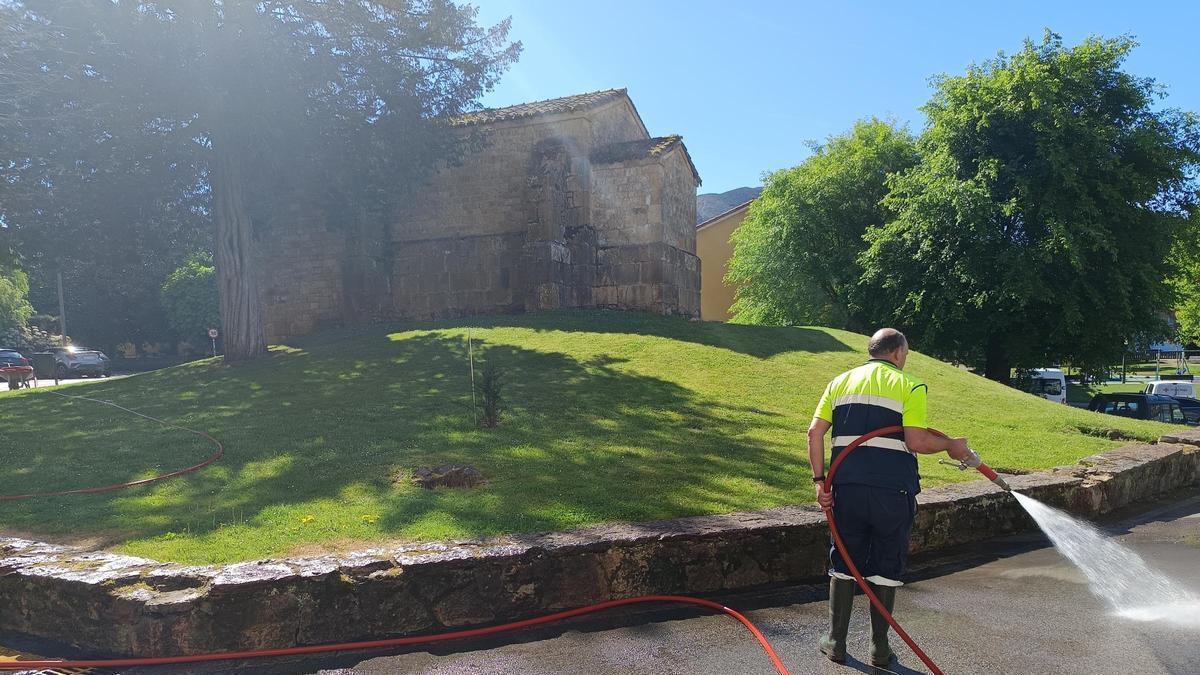 Un operario baldea el entorno de la capilla Santa Cruz.