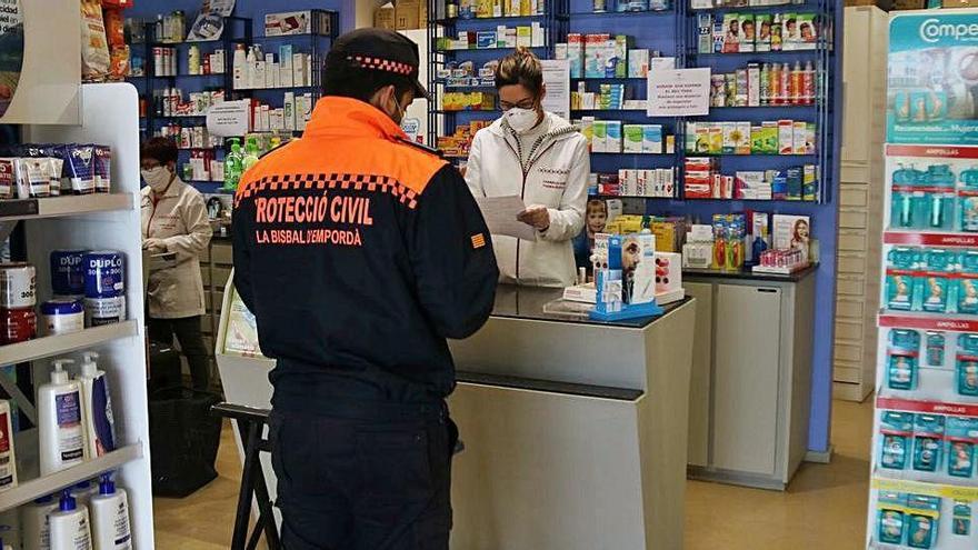 Un voluntari de Protecció Civil comprant medicaments a la Bisbal d&#039;Empordà.
