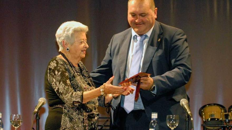 Fifi Urbina recibe una placa de Ramón Argüelles.