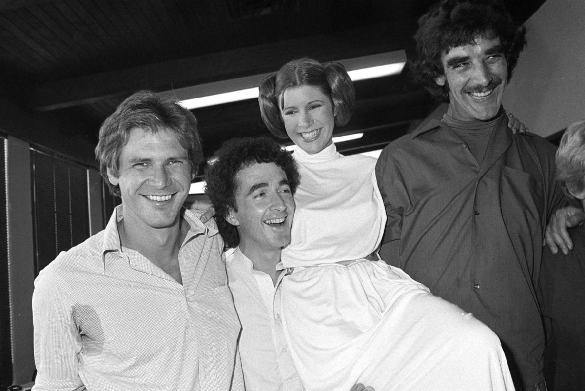 FILE - In this Oct. 5, 1978 photo, from left, actors Harrison Ford, Anthony Daniels, Carrie Fisher and Peter Mayhew take a break from filming a television special in Los Angeles to be telecast during the holidays. On Tuesday, Dec. 27, 2016, a publicist says Fisher has died at the age of 60. (AP Photo/George Brich, File)