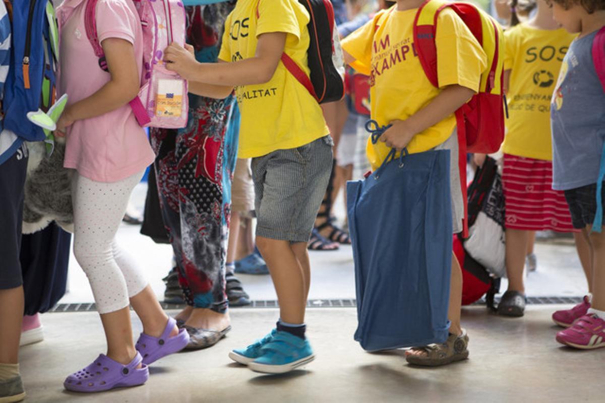 Niños del colegio Fructuós Gelabert en la fila para entrar a las aulas.