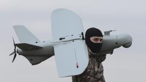 Un soldado ucraniano carga con un dron de fabricación nacional