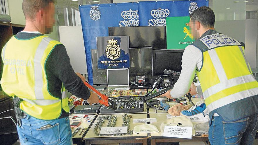 Dos agentes junto al material incautado en la operación.