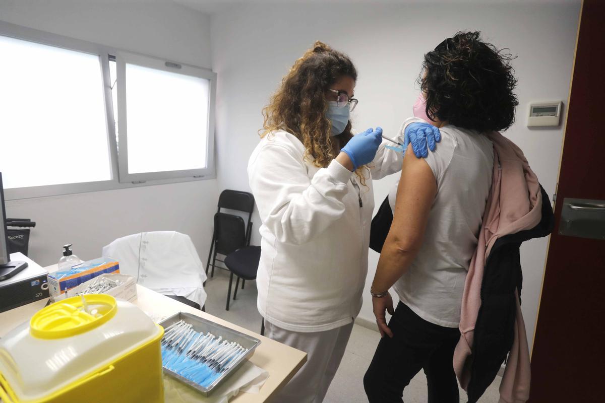 Una sanitaria administrando la tercera dosis de la vacuna del covid con Moderna