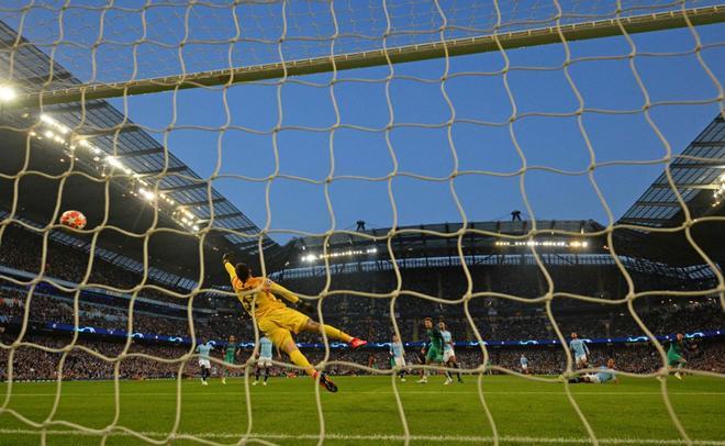 Son Heung-Min (R), anota el segundo gol de su equipo ante el portero Ederson durante el partido de fútbol de la UEFA Champions League entre Manchester City y Tottenham Hotspur en el Estadio Etihad en Manchester, en el noroeste de Inglaterra.