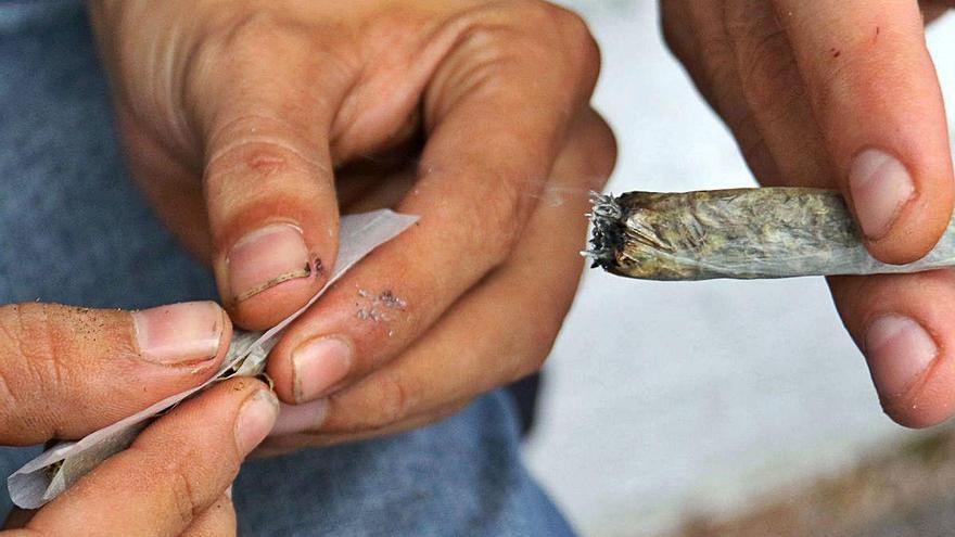 Un hombre prepara un cigarrillo de marihuana orgánica durante una manifestación.