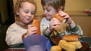 Dos niños comiendo bollería.