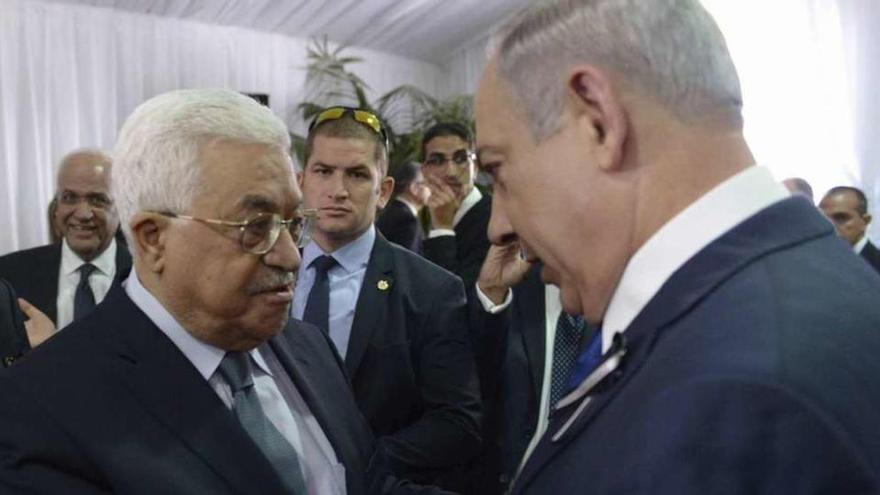 Abás (a la izquierda) y Netanyahu se saludan antes del comienzo del funeral de Simon Peres. // Efe